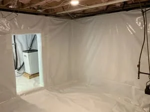 Crawl space with white polyethylene vapor barrier encapsulation and dehumidifier unit installed
