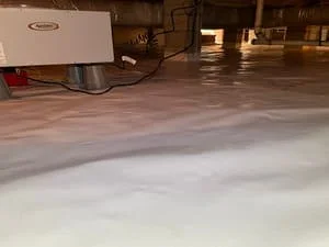 Crawl space with white vapor barrier moisture barrier installed on floor