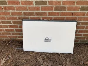White vapor barrier encapsulation installed on crawl space foundation against brick wall