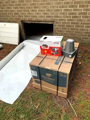 White vapor barrier and encapsulation materials installed in crawl space against brick foundation